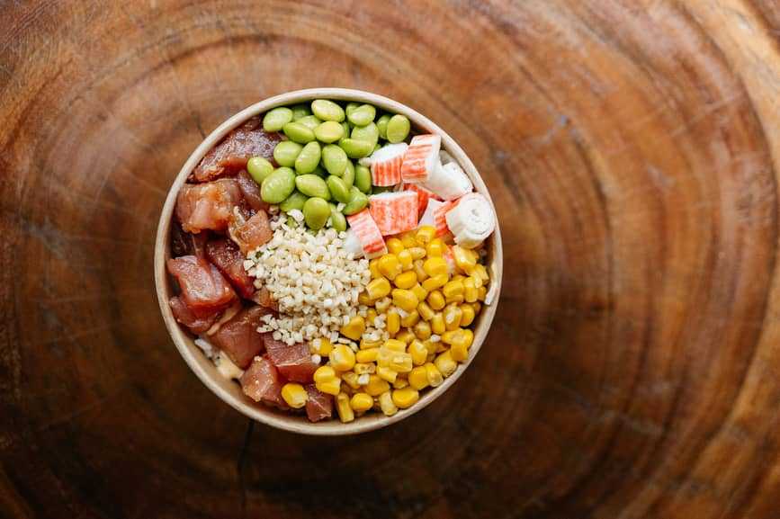From above view of fresh poké bowl on a wood table By Sergio Marcos